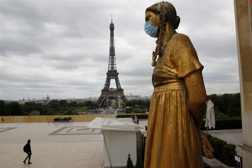 Μάσκα σε άγαλμα με φόντο τον Πύργοτου Αϊφελ (AP Photo/Christophe Ena)