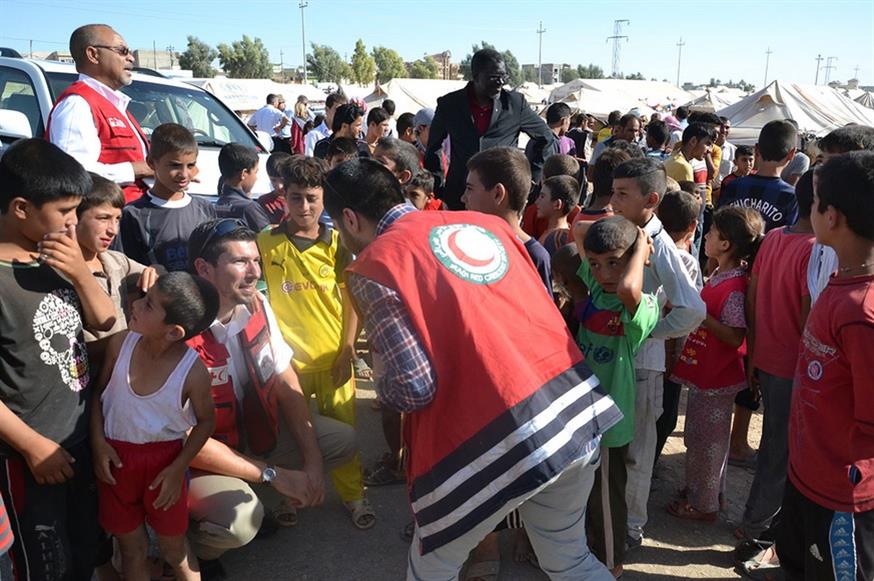 Μέλη του Ερυθρού Σταυρού με παιδάκια στο Ιράκ (Red Cross)