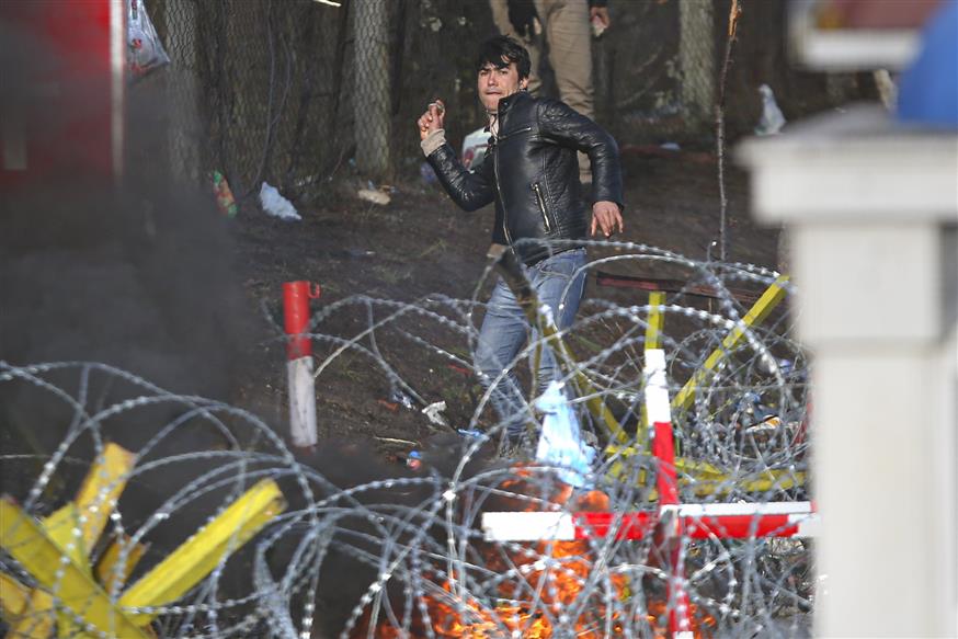 Πρόσφυγας ή μετανάστης πετάει πέτρες στα ελληνοτουρκικά σύνορα (AP Photo/Giannis Papanikos)