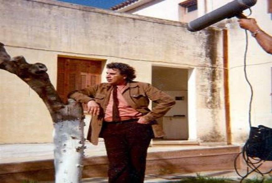 Ο Μίκης Θεοδωράκης, to 1983 σε ηλικία 58 ετών στα γυρίσματα του ντοκιμαντέρ «Μίκης Θεοδωράκης - Αυτοβιογραφία»  έξω από το κελί του στις Παλαιές Φυλακές Ωρωπού