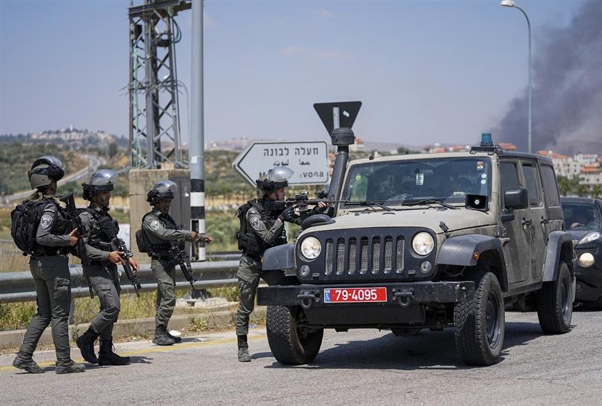 Μέλη του ισραηλινού στρατού σταματούν διερχόμενα οχήματα στη Δυτική Όχθη (Associated Press)