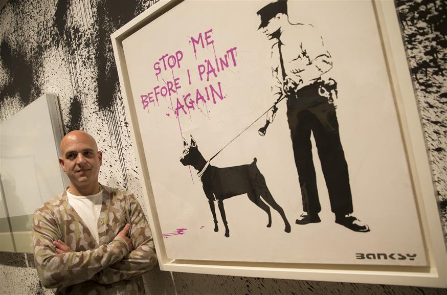 Ο Στιβ Λαζαρίδης μπροστά σε πίνακα του Bansky (Φωτογραφία: AP Images)