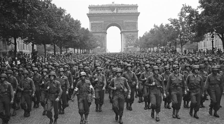 Αμερικανοί στρατιώτες της 28ης Μεραρχίας Πεζικού της Πενσυλβάνια παρελαύνουν στις 29 Αυγούστου 1944, τέσσερις ημέρες μετά την απελευθέρωση του Παρισιού, κατά μήκος των Ηλυσίων Πεδίων, στο βάθος η Αψίδα του Θριάμβου./copyright AP PHOTOS
