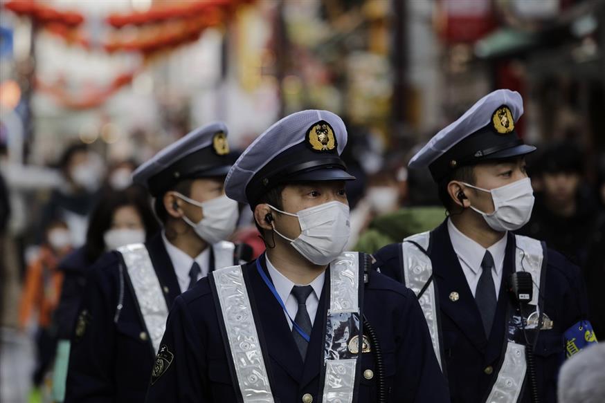 Ανδρες των αρχών ασφαλείας με μάσκες. Αλλά η ανησυχία δεν κρύβεται (AP Photo/Jae C. Hong)