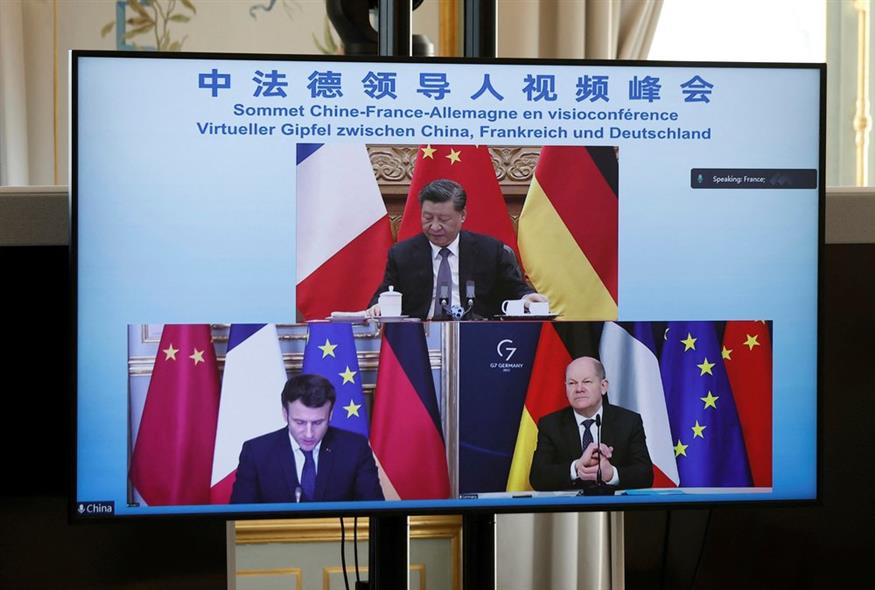 Tηλεοπτική οθόνη δείχνει τον Γάλλο πρόεδρο Εμανουέλ Μακρόν, τον Γερμανό καγκελάριο Όλαφ Σολτς, κάτω δεξιά, και τον Κινέζο πρόεδρο Σι Τζινπίνγκ / Benoit Tessier/Pool via AP