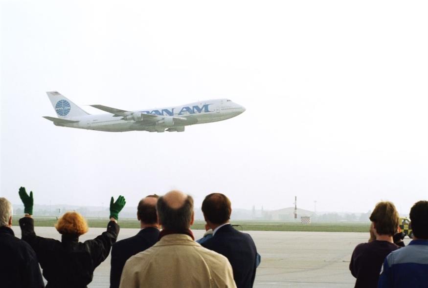 Πολίτες χαιρετούν καθώς το Boeing 747 της Pan American Airlines με την ονομασία Clipper Voyager απογειώνεται από το Διεθνές Αεροδρόμιο της Φρανκφούρτης, Γερμανία, την 1η Νοεμβρίου 1991. Η πτήση με προορισμό τη Νέα Υόρκη ήταν η τελευταία πτήση της Pan Am στη Φρανκφούρτη. Η Pan Am εγκατέλειψε το μεγαλύτερο μέρος των υπερπόντιων βάσεων της, καθώς η Delta Air Lines ανέλαβε, εισάγοντας τη Delta σταθερά στις τάξεις των παγκόσμιων υπερδυνάμεων της αεροπορίας. (AP Photo/Kurt Strumpf)