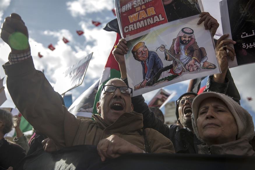 Διαδηλωτές δείχνουν σε πλακάτ τούς -κατά τη γνώμη τους- ενόχους της δολοφονίας (AP Photo/Hassene Dridi)