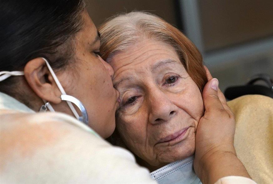 Γυναίκα αγκαλιάζει τη μητέρα της που πάσχει από άνοια (φωτογραφία αρχείου / Associated Press)