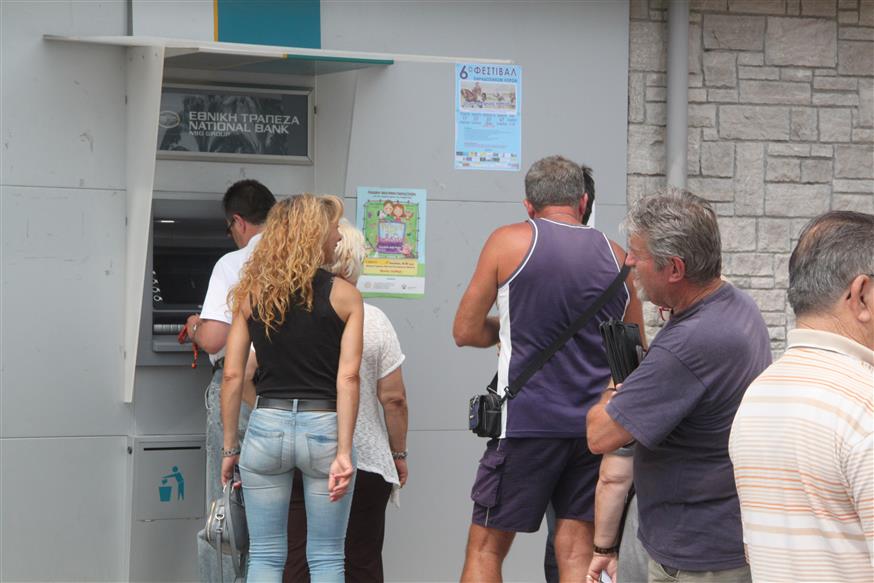 Πολίτες περιμένουν να εξυπηρετηθούν σε μηχάνημα αυτόματων συναλλαγών (Eurokinissi)