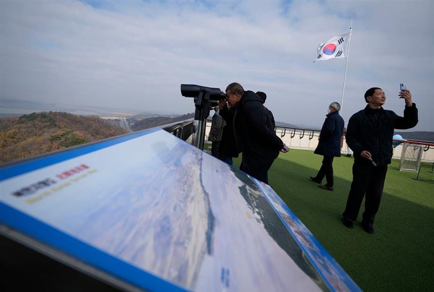 Οι επισκέπτες χρησιμοποιούν κιάλια για να δουν τη βορειοκορεατική πλευρά (AP Photo/Lee Jin-man)