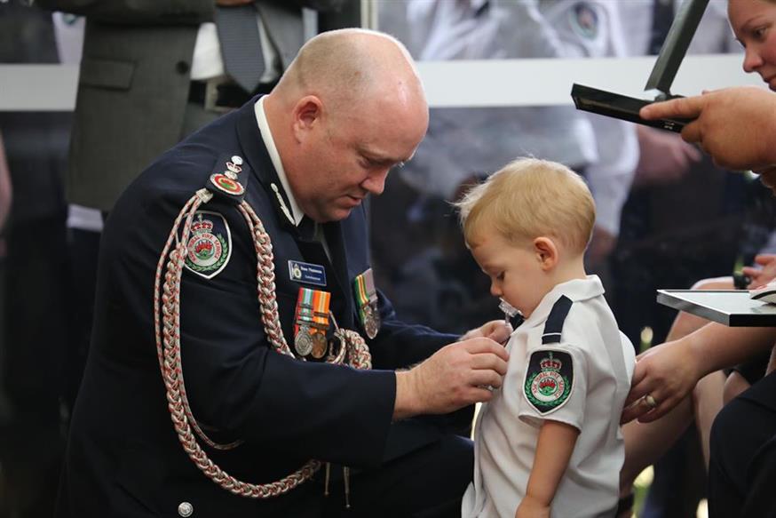 Ο μικρός Harvey παραλαμβάνει το παράσημο του πατέρα του/NSW Rural Fire Service