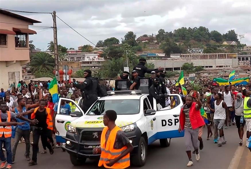 Υποστηρικτές του πραξικοπήματος επευφημούν αστυνομικούς στη Λιμπρεβίλ της Γκαμπόν (Associated Press)
