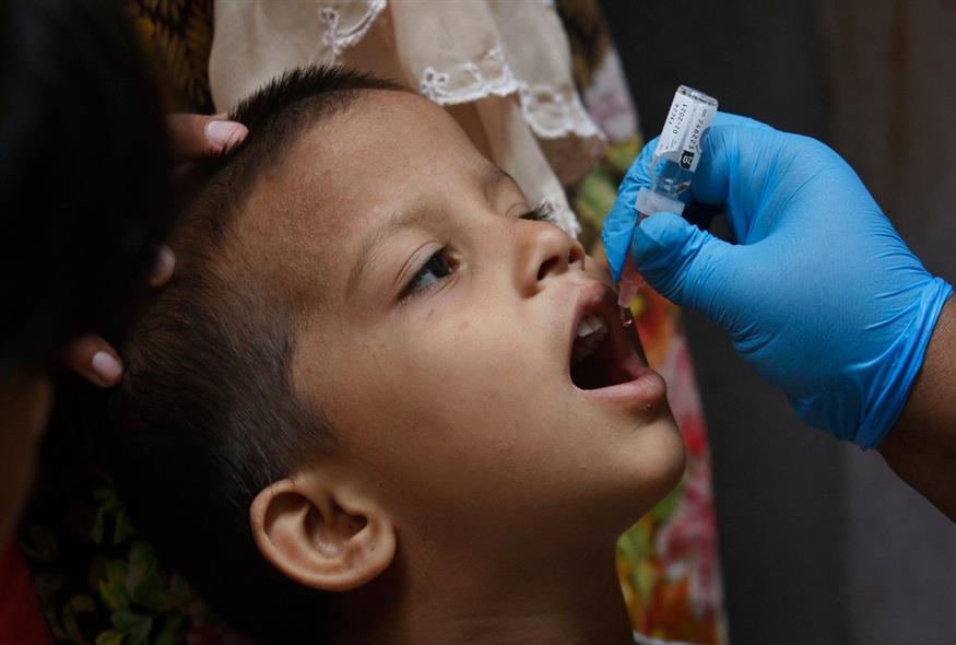 Ένας εργαζόμενος στον τομέα της υγείας κάνει εμβόλιο πολιομυελίτιδας σε ένα παιδί / AP Photo/Fareed Khan