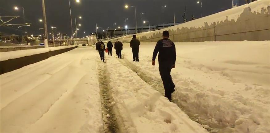 Εγκλωβισμένοι περπατάνε μέσα στη χιονισμένη Αττική Οδό με τη συνοδεία αστυνομικών